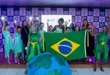 Várias pessoas posando para foto segurando a Bandeira Nacional