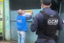 Agente da prefeitura afixando documento de interdição