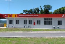 Base 13 da CCR RioSP na rodovia Rio-Santos, com fachada branca e marquise vermelha identificada como Serviço de Atendimento ao Usuário, em área cercada por vegetação em operação especial para o carnaval.