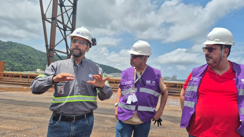 O diretor explicando as operações do porto para dois ouvintes