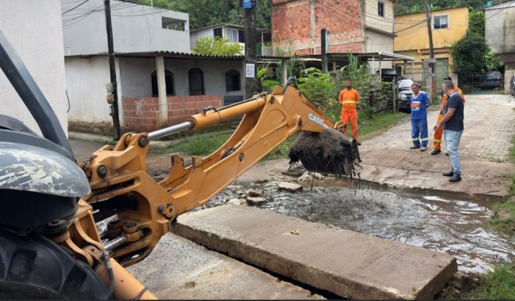 Equipes realizam a desobstrução de galeria pluvial com auxílio de retroescavadeira