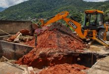 Retroescavadeira em ação no local do desabamento