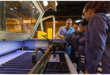 Alunos em torno de uma máquina