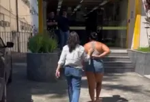 mulher sendo levada a delegacia