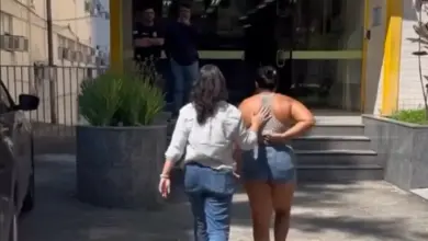 mulher sendo levada a delegacia