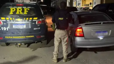 Agente da PRF entre o veículo apreendido e a viatura