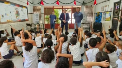 Crianças fazendo sinal afirmativo para um palestrante