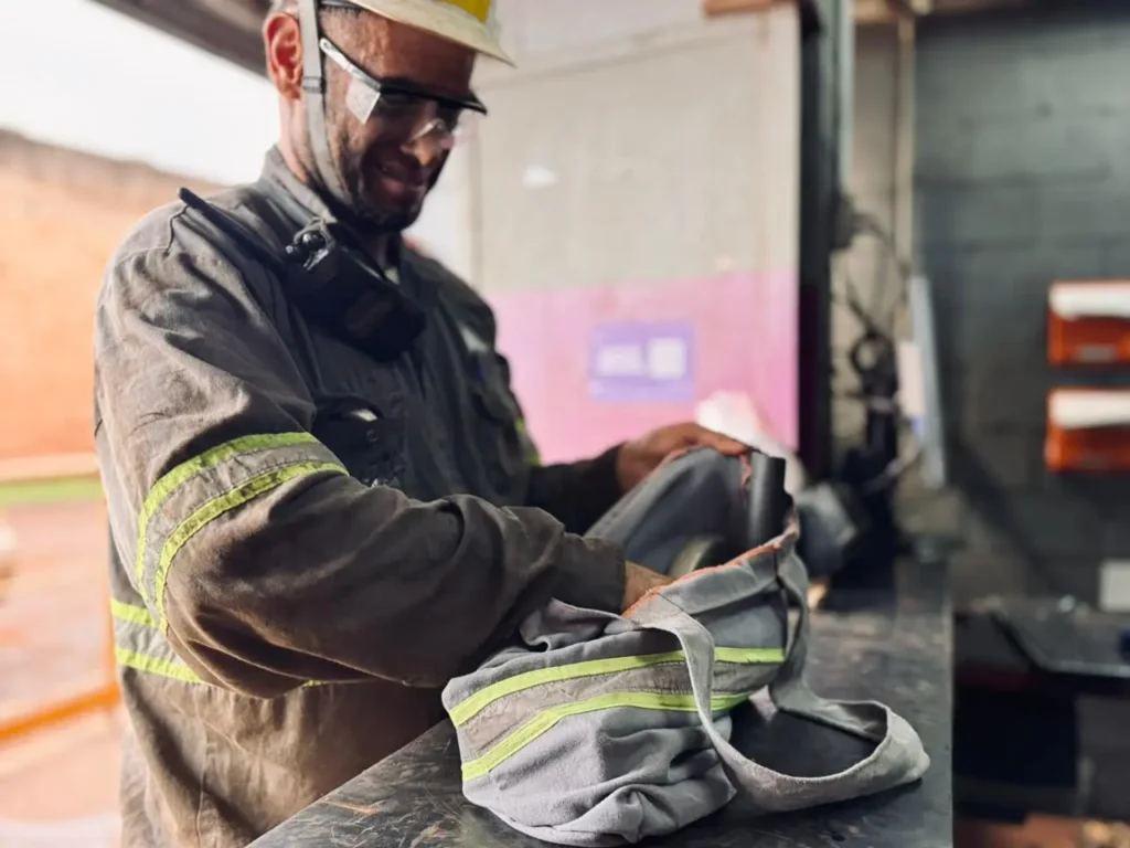 Colaborador mexendo numa mochila feita de uniforme reciclado
