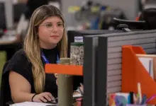 Jovem sentada à frente de um computador