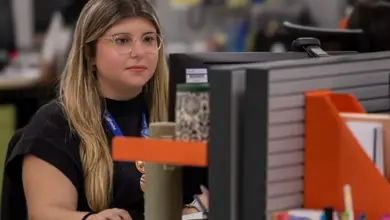 Jovem sentada à frente de um computador