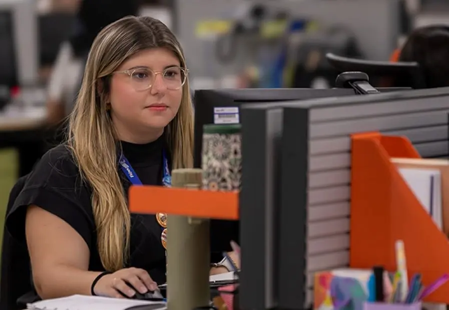 Jovem sentada à frente de um computador