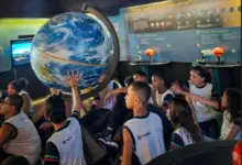 Alunos do CIEP 496 observando de perto um modelo do planeta Terra