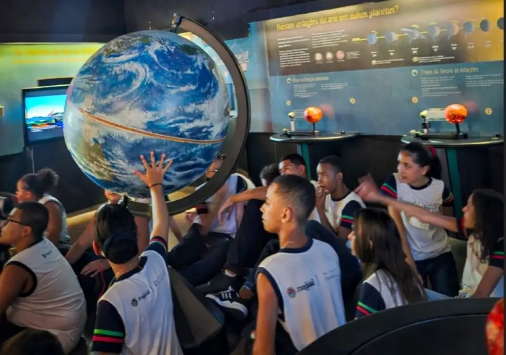 Alunos do CIEP 496 observando de perto um modelo do planeta Terra