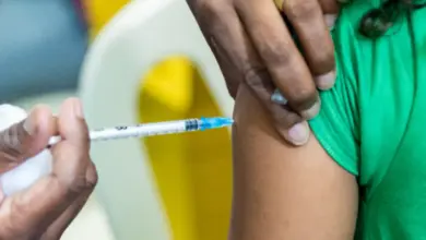 Profissinal da área da saúde aplica vacina em criança