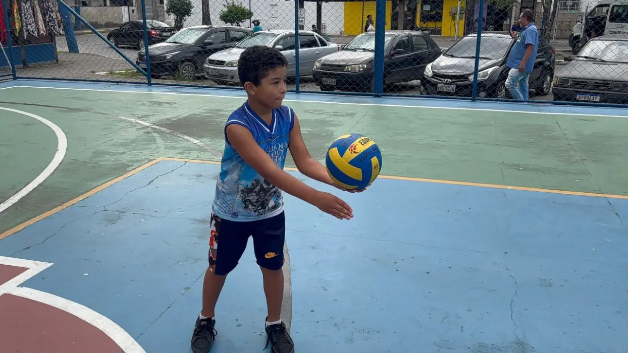 Criança participa de atividade de vôlei em quadra poliesportiva revitalizada em Mangaratiba