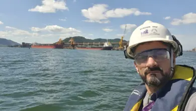 Homem em embarcação com mar ao fundo