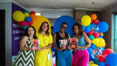 Quatro mulheres posando para fotos com livros à mão