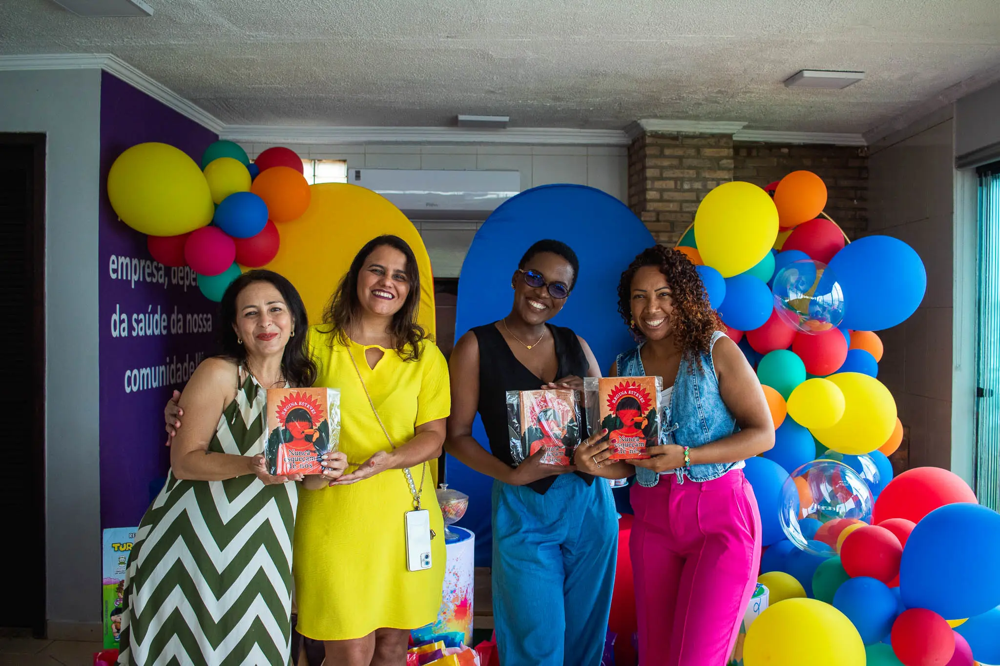 Quatro mulheres posando para fotos com livros à mão