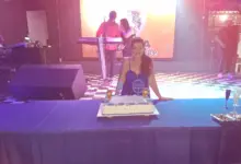 Aniversariante à mesa com bolo de seu aniversário