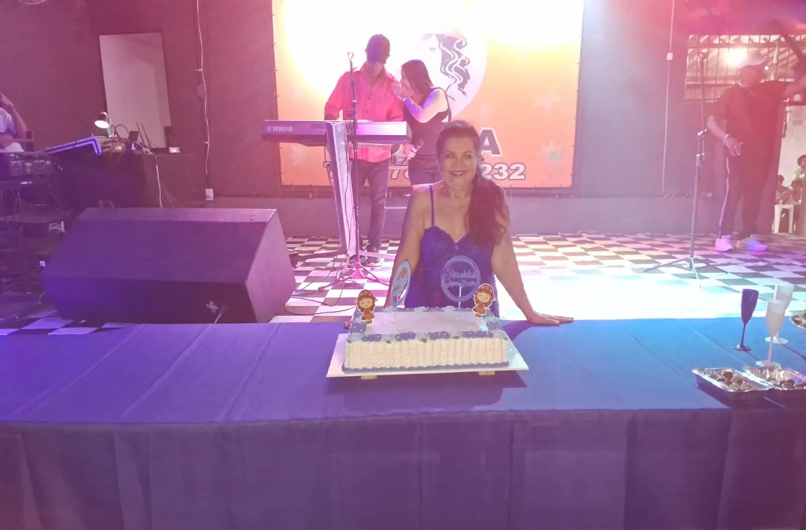 Aniversariante à mesa com bolo de seu aniversário