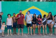 Moradores e crianças do bairro Estrela do Céu participam da pintura do muro da Escola Municipal Elmira Figueira, em Itaguaí, resgatando a tradição das ruas decoradas para a Copa do Mundo de 2026 (FOTOS: BERNARDO FILMES).
