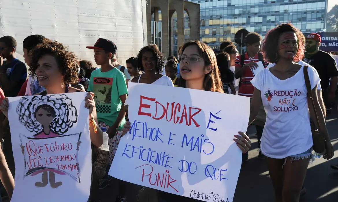 Protesto com cartaz escrito "Educar é melhor e mais eficiente do que punir."