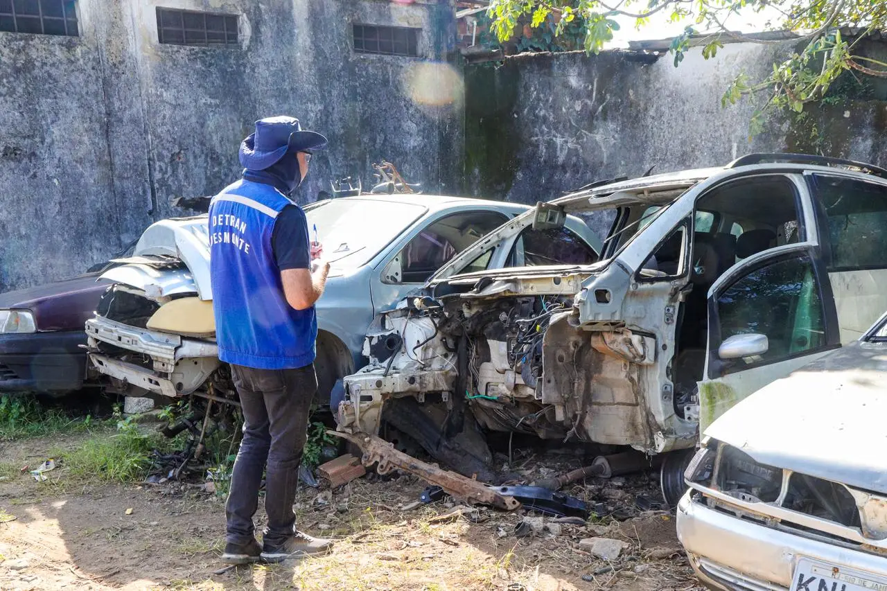 Agente olhando carcaça de automóveis