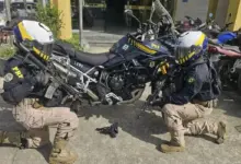 Agentes do Grupo de Motociclismo Policial da PRF exibem a arma apreendida durante ação