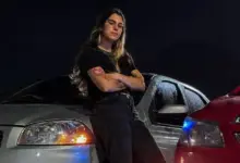 Colaboradora do Porto Sudeste posando enconstada num automóvel