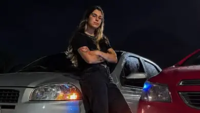 Colaboradora do Porto Sudeste posando enconstada num automóvel