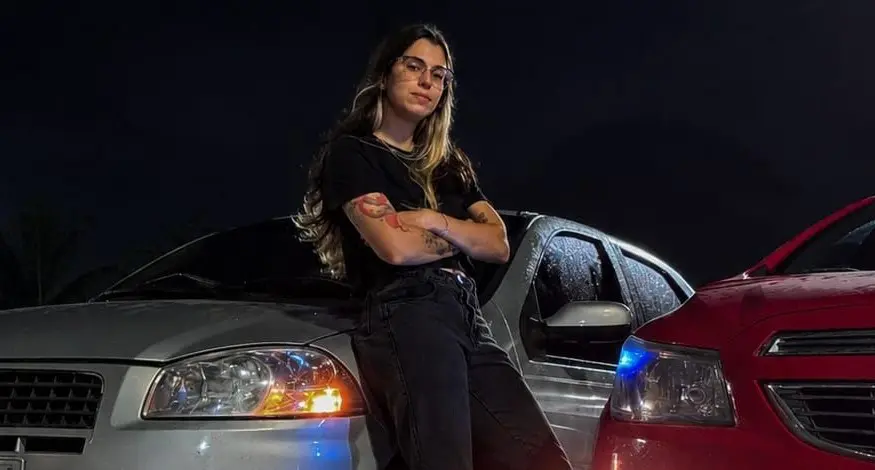 Colaboradora do Porto Sudeste posando enconstada num automóvel