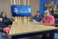 Entrevistada e entrevistadores sentados à mesa