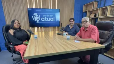 Entrevistada e entrevistadores sentados à mesa