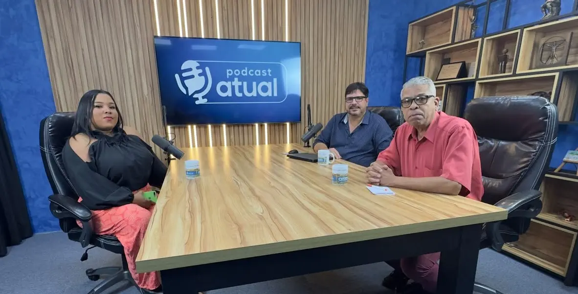 Entrevistada e entrevistadores sentados à mesa