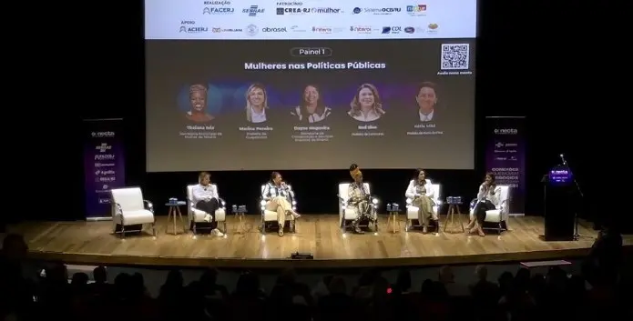 Cinco mulheres sentadas debatendo