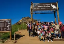 Participantes do "Um Dia no Parque" reunidos no letreiro de acesso ao Parque