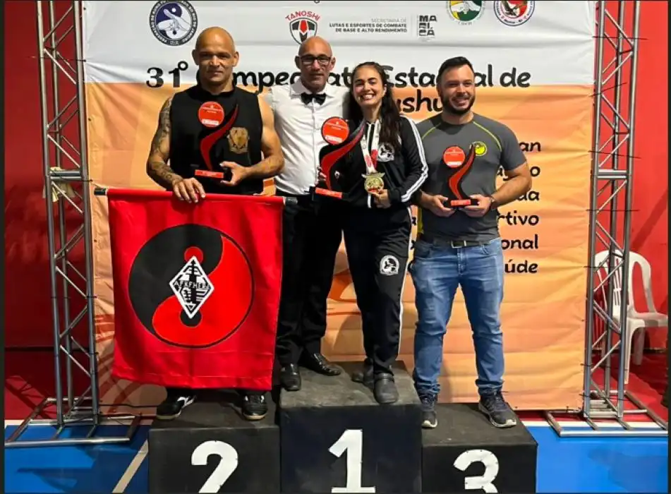 No topo do pódio! O mestre Evandro Gonçalves e a atleta Karina Rabelo celebram a conquista do troféu