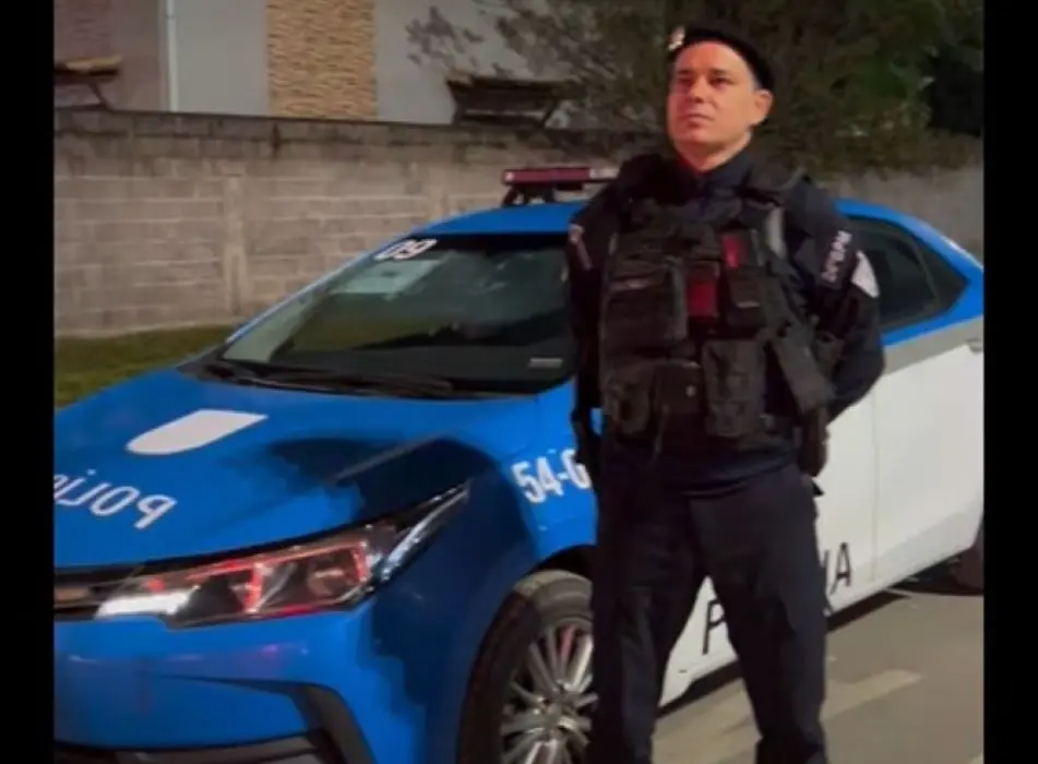 Policial militar ao lado da viatura