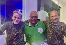 Três homens posando para foto sorrindo