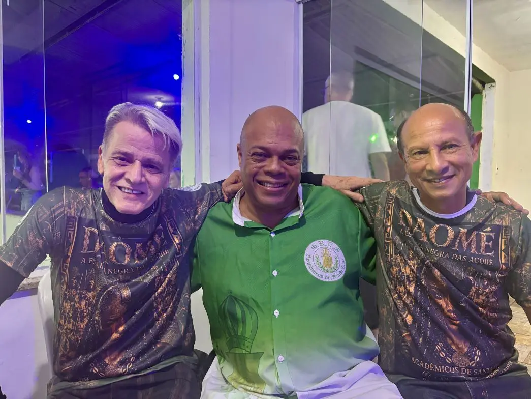 Três homens posando para foto sorrindo
