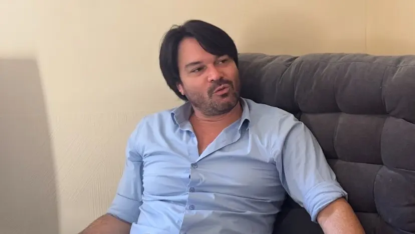 Luciano Mota sentado Num sofá