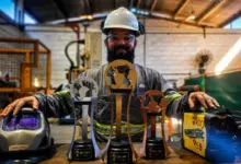 Colaborador exibindo troféu confeccionado por ele
