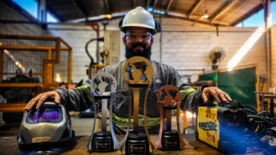 Colaborador exibindo troféu confeccionado por ele
