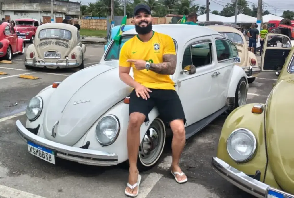 Colaborador posando ao lado do seu Fusca