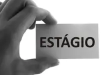 Mão segunrando placa em que está escrito a palavra estágio