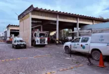 Vista do pátio da unidade da Light em Itaguaí, com diversas caminhonetes, caminhões e veículos operacionais estacionados sob um galpão. A imagem foi registrada durante apuração do Jornal Atual, enquanto bairros do município ainda enfrentavam falta de energia após o vendaval.