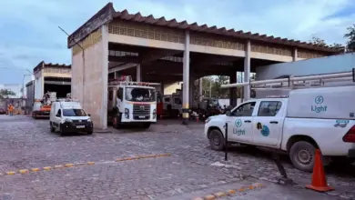 Vista do pátio da unidade da Light em Itaguaí, com diversas caminhonetes, caminhões e veículos operacionais estacionados sob um galpão. A imagem foi registrada durante apuração do Jornal Atual, enquanto bairros do município ainda enfrentavam falta de energia após o vendaval.