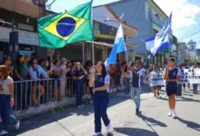 Alunos participam do Desfile Cívico de Itacuruçá conduzindo as bandeiras do Brasil, do Estado do Rio de Janeiro e de Mangaratiba