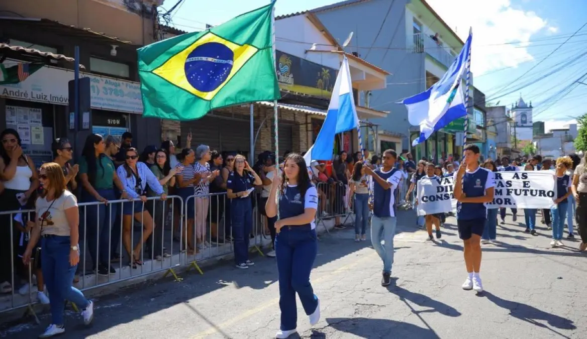 Alunos participam do Desfile Cívico de Itacuruçá conduzindo as bandeiras do Brasil, do Estado do Rio de Janeiro e de Mangaratiba