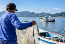 Pescador artesanal realiza atividade de pesca em embarcação